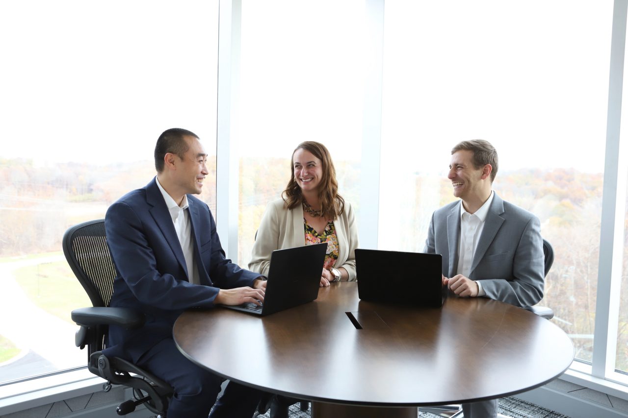 Three First American colleagues sitting around a round table.
