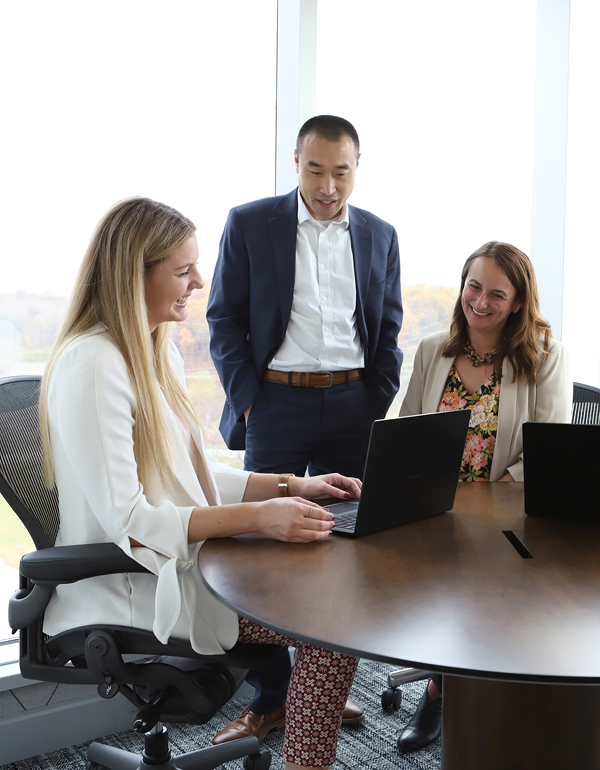 FAEF colleagues smiling and working on a laptop