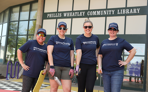 First American colleagues perform yard work at a local library