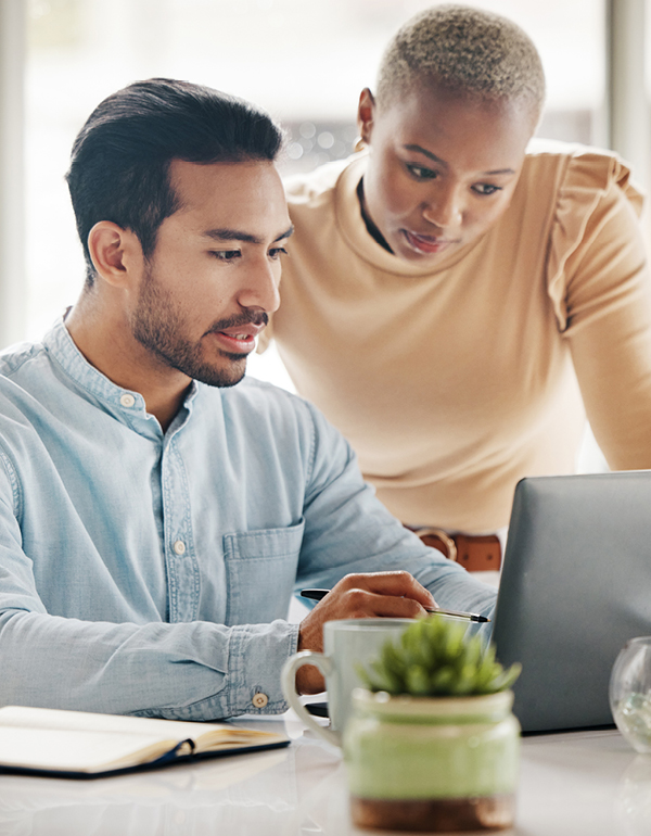 Two business professionals smiling and working on laptop