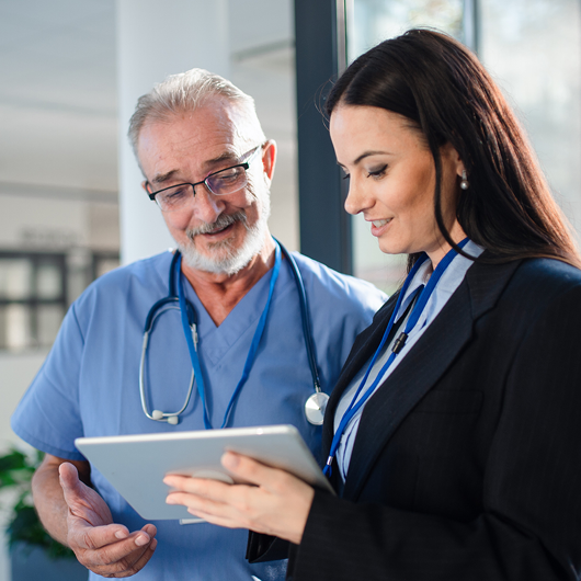 Two healthcare busines professionals working on tablet