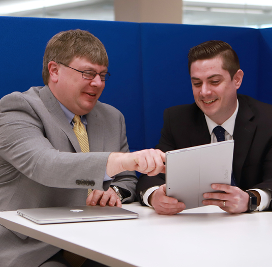 Woman and man collaborating on tablet