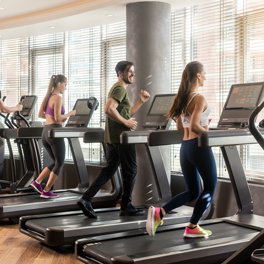 People running and walking on treadmills at the gym