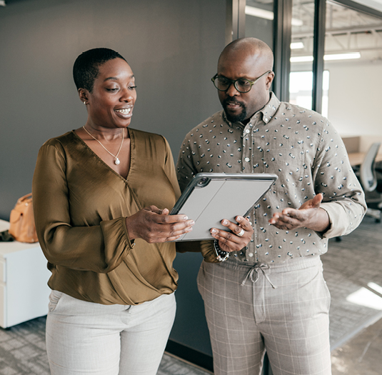 Woman and man collaborating on tablet