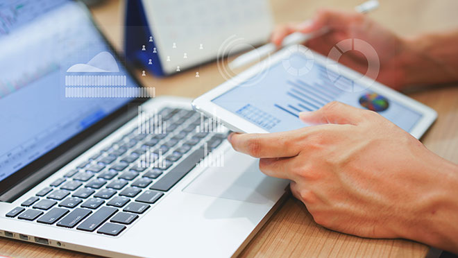 Person typing on a laptop and holding a credit card