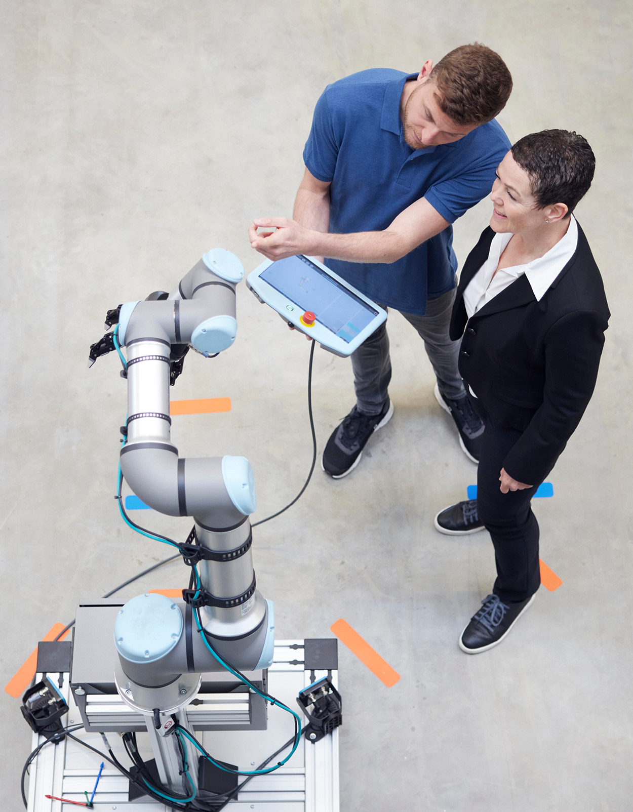 Two workers programming AI robot.