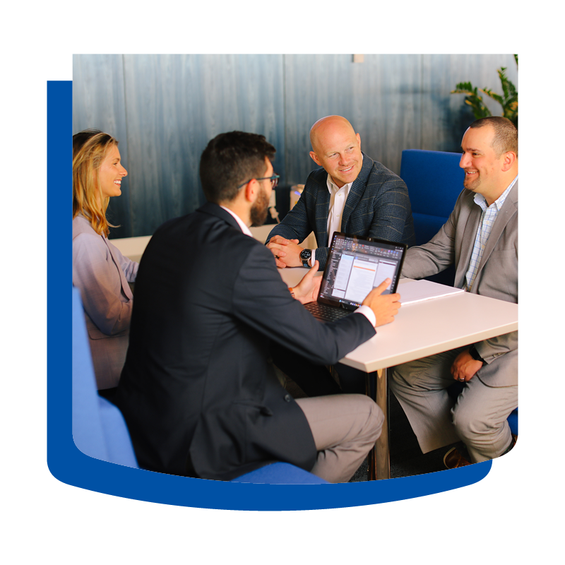 Four First American colleagues sitting around table, smiling and collaborating.