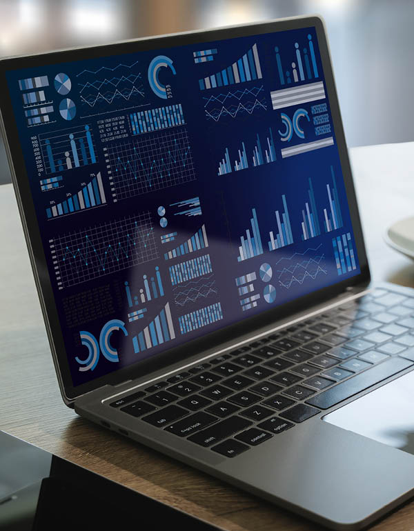 Laptop displaying multiple charts and graphs on a dark blue screen, representing data analysis and visualization.