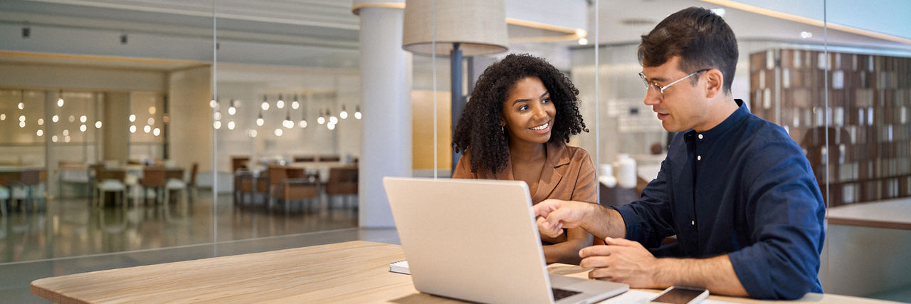 Two business professionals collaborating at a table in the office.