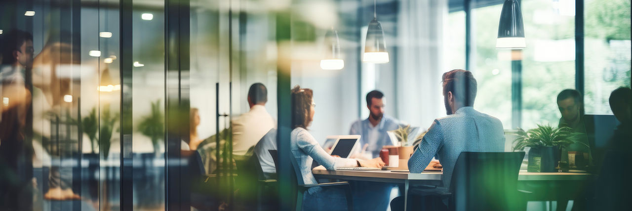 View outside of a window looking into colleagues working in office.