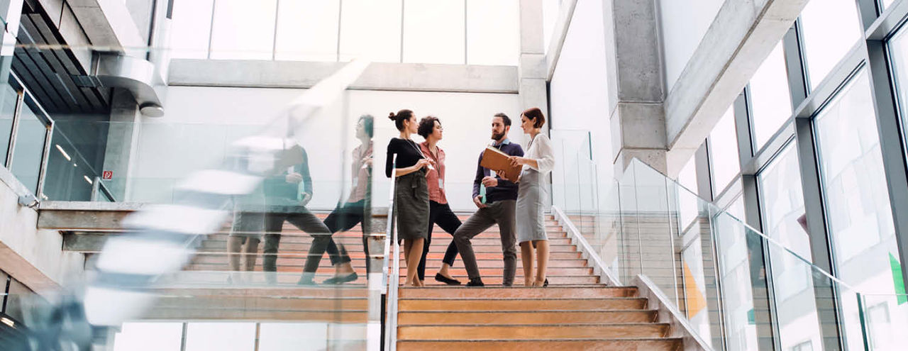 People standing on stairs in modern office building 
