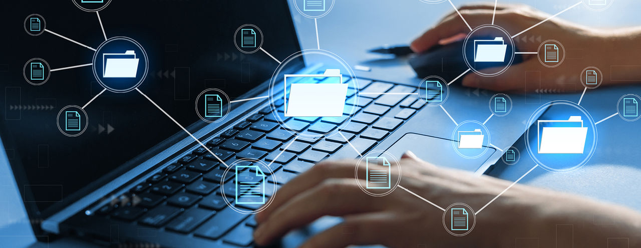Person typing on laptop with icons.