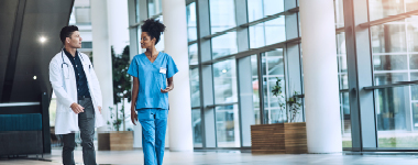 Medical practitioners having a conversation in a hospital hallway.