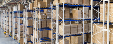 Boxes with goods on shelves in a large distribution warehouse with metal racking storage system