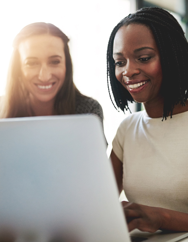 Two business professionals smiling and working on laptop