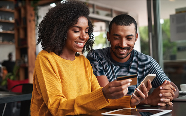 People looking at a credit card and smartphone