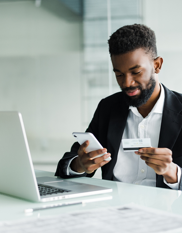 Man using laptop, phone and credit card