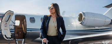 Person standing beside a private jet.