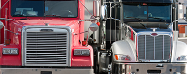 Close-up of 2 fleet tractor trailer trucks