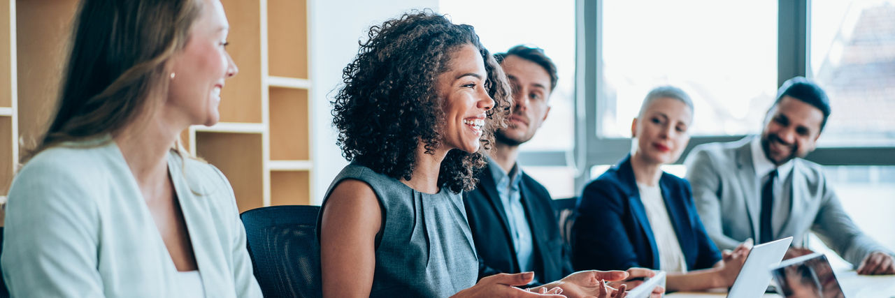 Colleagues smiling together at a meeting